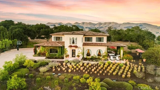 a front view of a house with a yard and trees