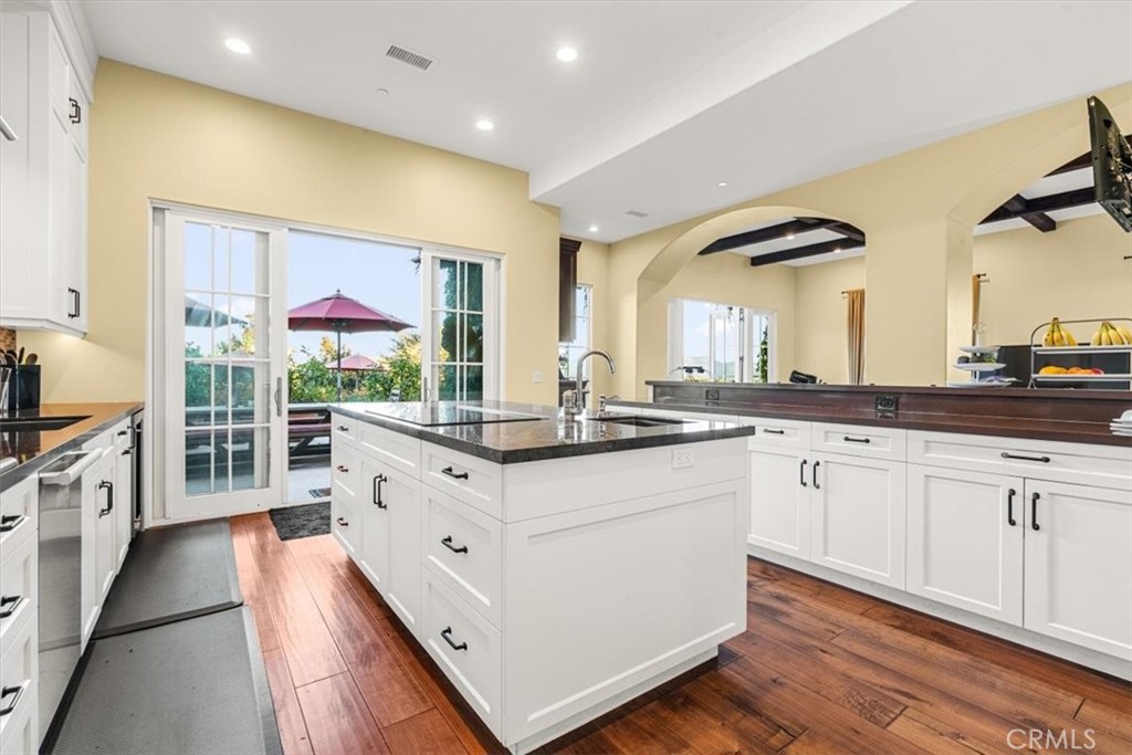 455 Mission Springs Road Arroyo Grande, CA 93420 - Photo 18 of 65 a large white kitchen with stainless steel appliances kitchen island granite countertop a sink and wooden floor