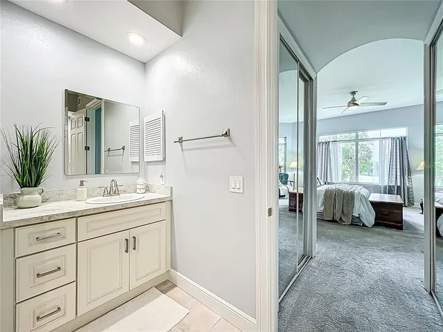 a view of a livingroom with furniture a potted plant and windows