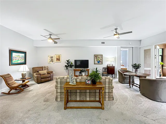 a living room with furniture and large windows