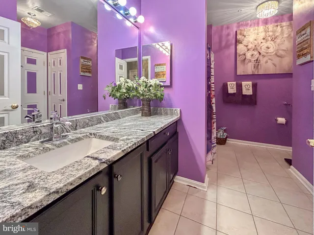 a bathroom with a granite countertop sink a mirror and a painted walls