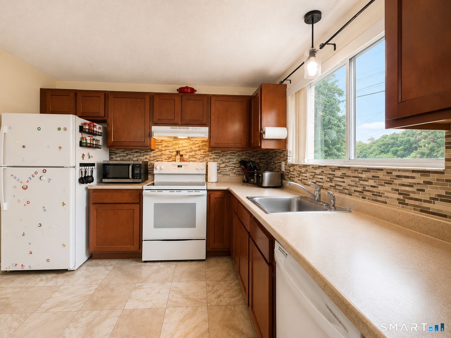 461 Spring Street, Unit 1A Naugatuck, CT 06770 - Photo 7 of 17 a kitchen with a sink white cabinets and white appliances