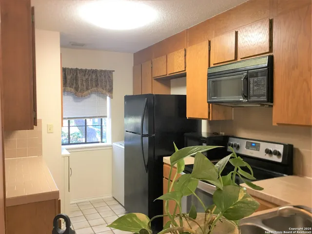 a kitchen with stainless steel appliances wooden cabinets a refrigerator and a stove