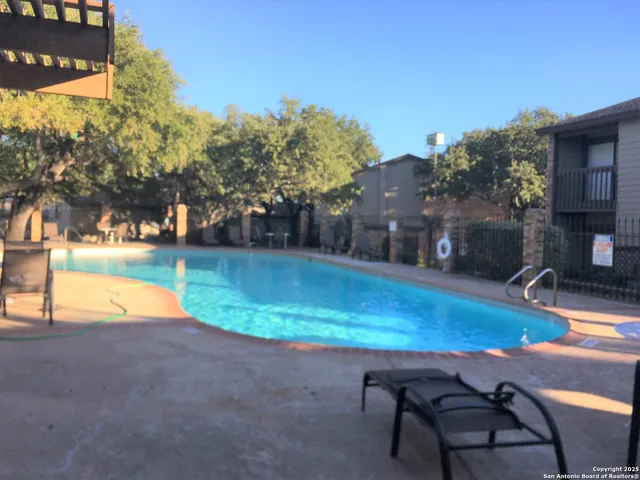a swimming pool with outdoor seating and yard