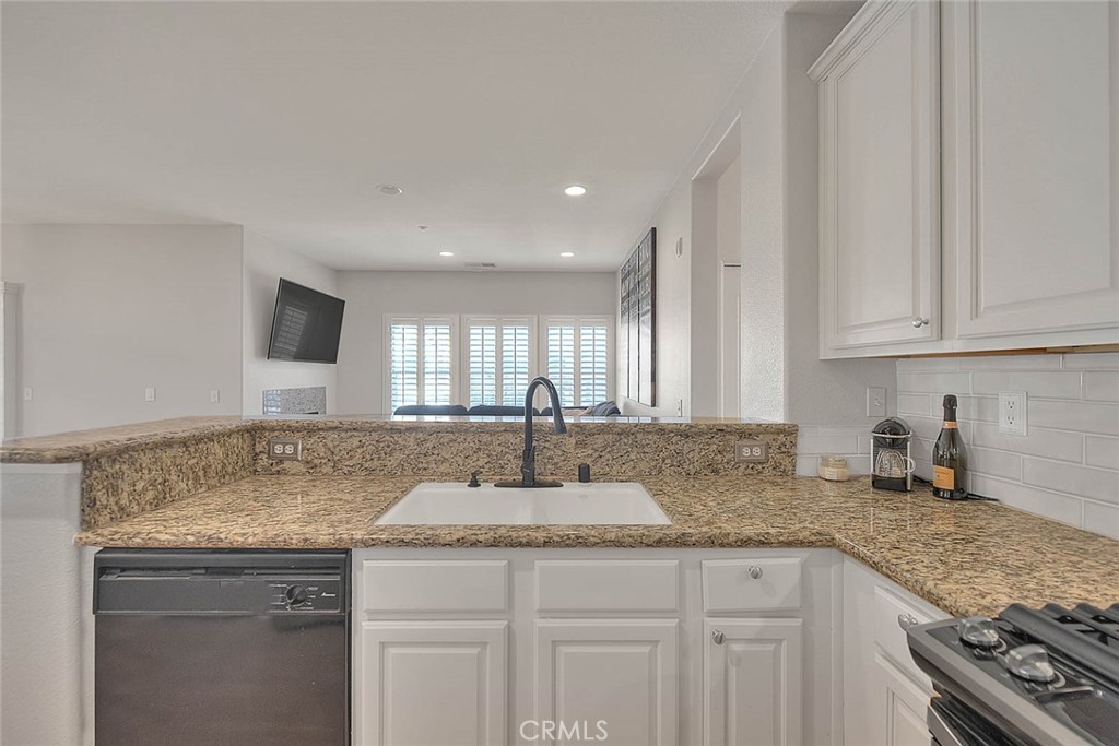 11450 Church Street, Unit 63 Rancho Cucamonga, CA 91730 - Photo 17 of 52 a kitchen with granite countertop a sink and cabinets