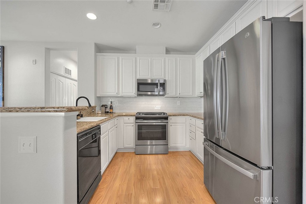 11450 Church Street, Unit 63 Rancho Cucamonga, CA 91730 - Photo 18 of 52 a kitchen with granite countertop a refrigerator stove and sink
