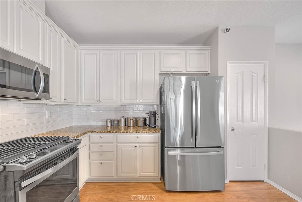 11450 Church Street, Unit 63 Rancho Cucamonga, CA 91730 - Photo 19 of 52 a kitchen with appliances a refrigerator and cabinets