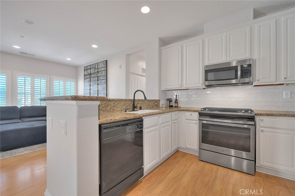 11450 Church Street, Unit 63 Rancho Cucamonga, CA 91730 - Photo 20 of 52 a kitchen with stainless steel appliances granite countertop a stove a sink and a microwave