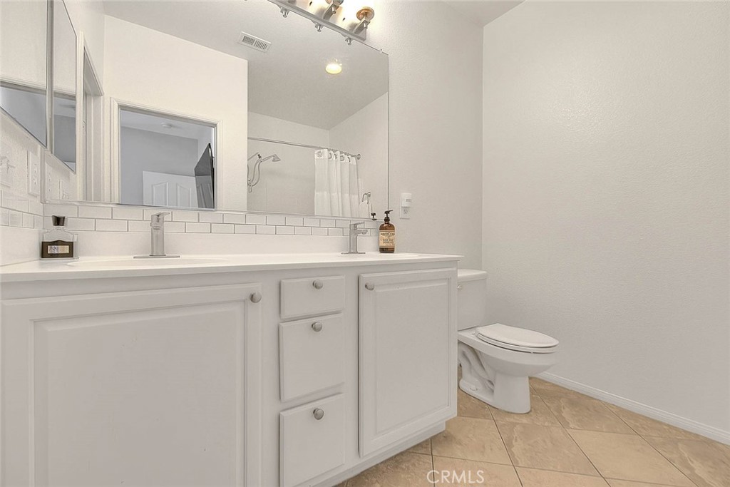 11450 Church Street, Unit 63 Rancho Cucamonga, CA 91730 - Photo 42 of 52 a bathroom with a toilet sink and mirror