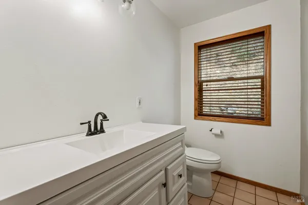 a bathroom with a sink a toilet and a window
