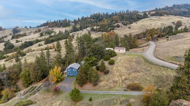 an aerial view of a house with a yard and mountain view in back