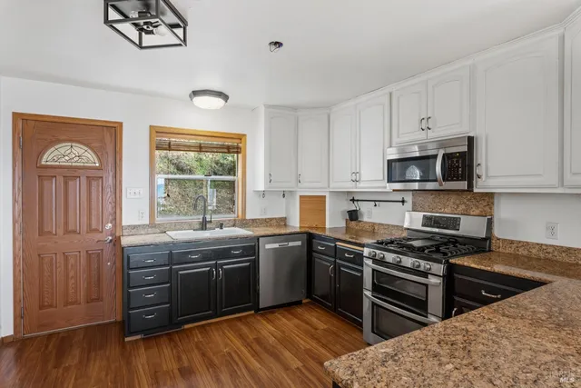 a kitchen with stainless steel appliances a stove sink and cabinets