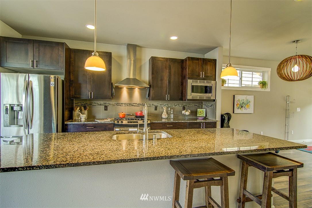 4417 Renton Avenue South Seattle, WA 98108 - Photo 6 of 21 a kitchen with stainless steel appliances granite countertop a sink and a refrigerator