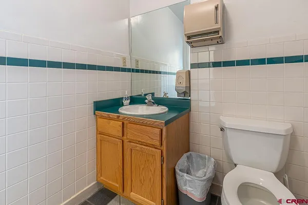 a bathroom with a granite countertop toilet and a sink