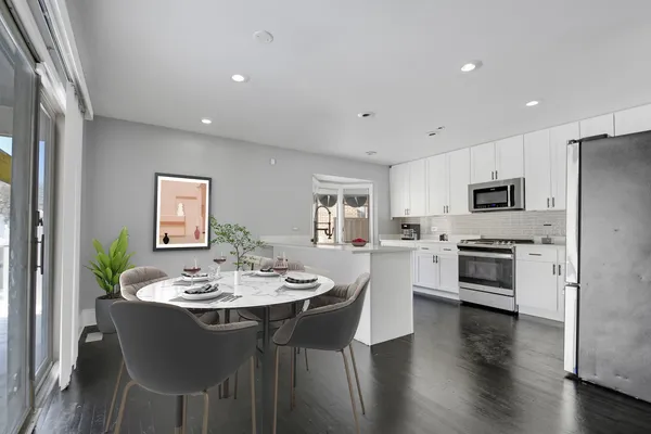 a view of a dining room with furniture wooden floor and a kitchen