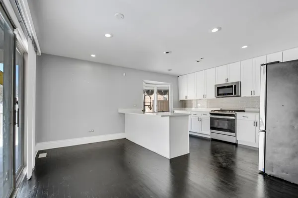 a view of kitchen with wooden floor and electronic appliances