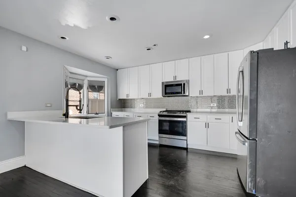 a kitchen with granite countertop white cabinets and white appliances
