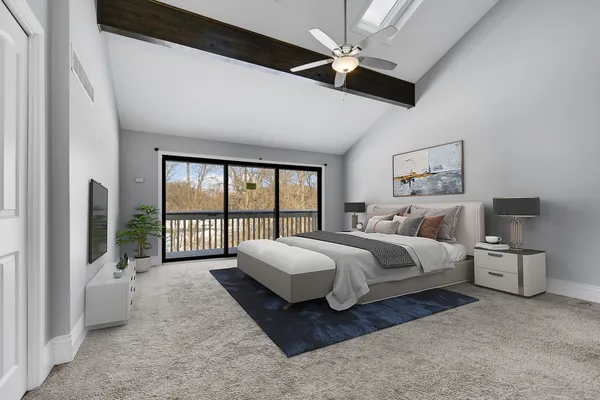 a spacious bedroom with a bed couch and a ceiling fan