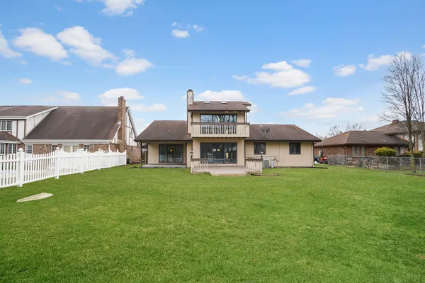 a view of a big house with a big yard and large trees