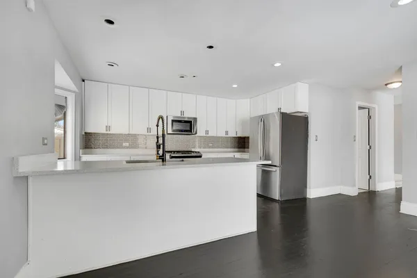 a kitchen with stainless steel appliances a refrigerator sink and microwave