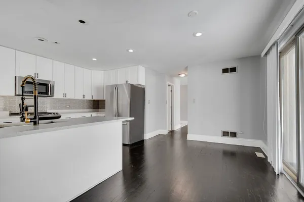 a kitchen with stainless steel appliances a refrigerator and a stove top oven