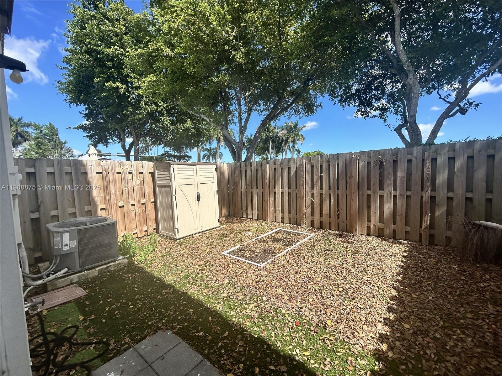 1685 Southeast 27th Street, Unit 1685 Homestead, FL 33035 - Photo 15 of 38 a view of backyard with wooden fence and large trees