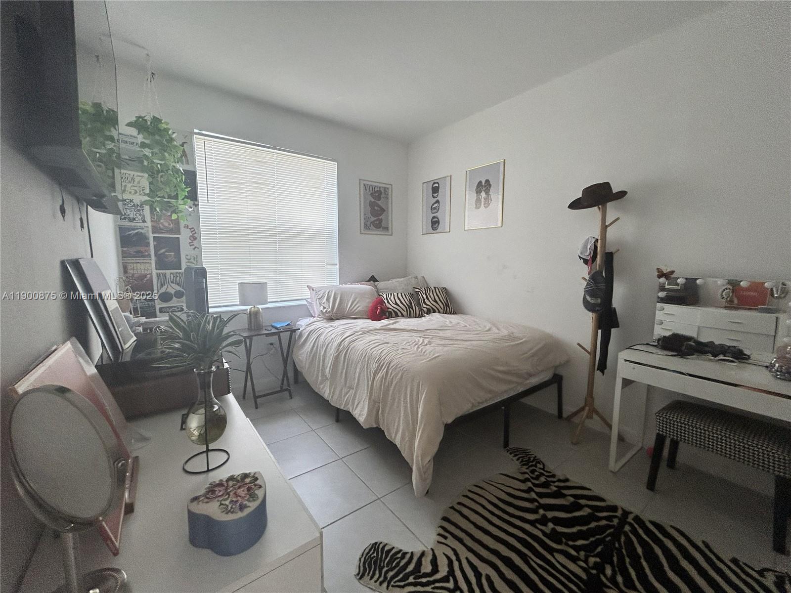 1685 Southeast 27th Street, Unit 1685 Homestead, FL 33035 - Photo 3 of 38 a bedroom with a bed and a chandelier