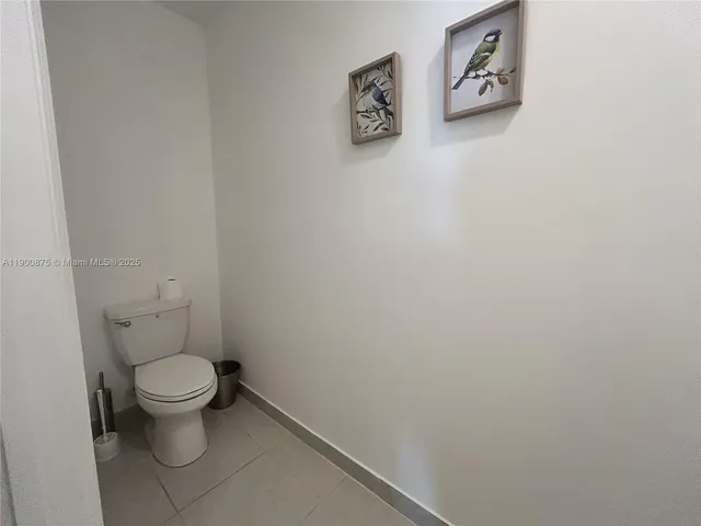 a white toilet sitting next to a white wall