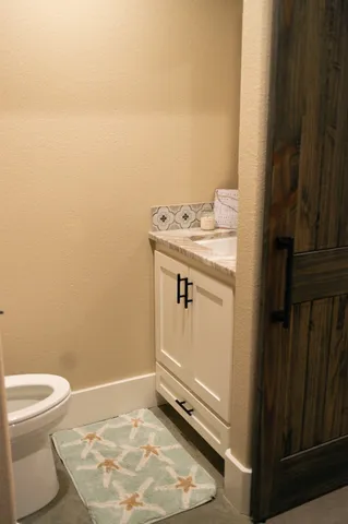 a bathroom with a granite countertop toilet and a sink
