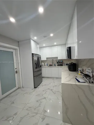 a kitchen with stainless steel appliances granite countertop a refrigerator sink and stove