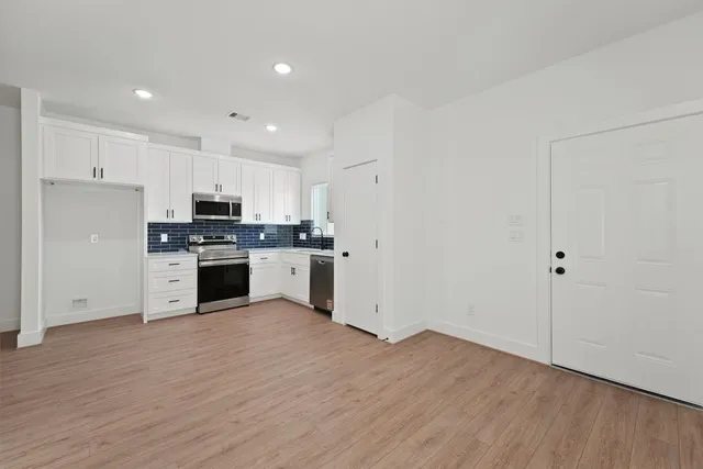 a kitchen with granite countertop a stove top oven and cabinets