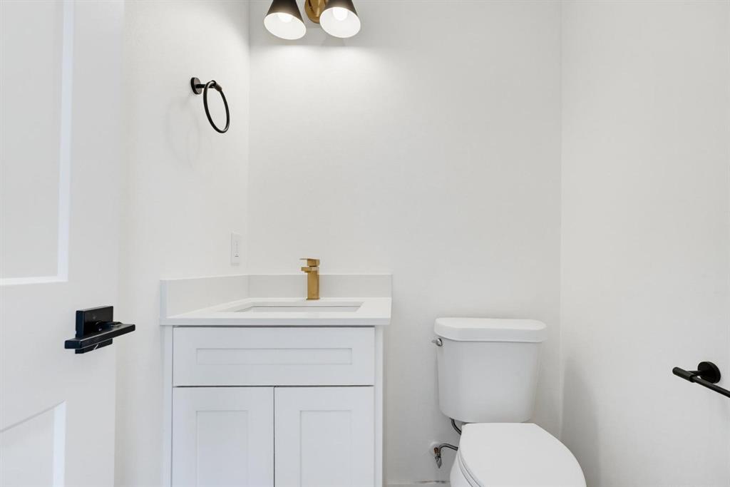 510 South O Connor Road Irving, TX 75060 - Photo 9 of 22 White vanity with shaker-style cabinetry, an integrated sink, and a gold-finish faucet
