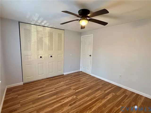 an empty room with closet and fan