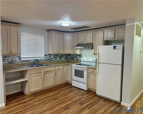 a kitchen with granite countertop white cabinets and white appliances