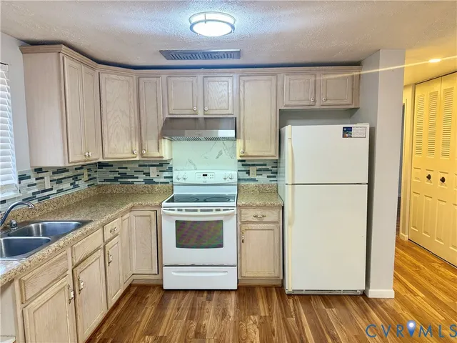 a kitchen with a refrigerator sink and cabinets