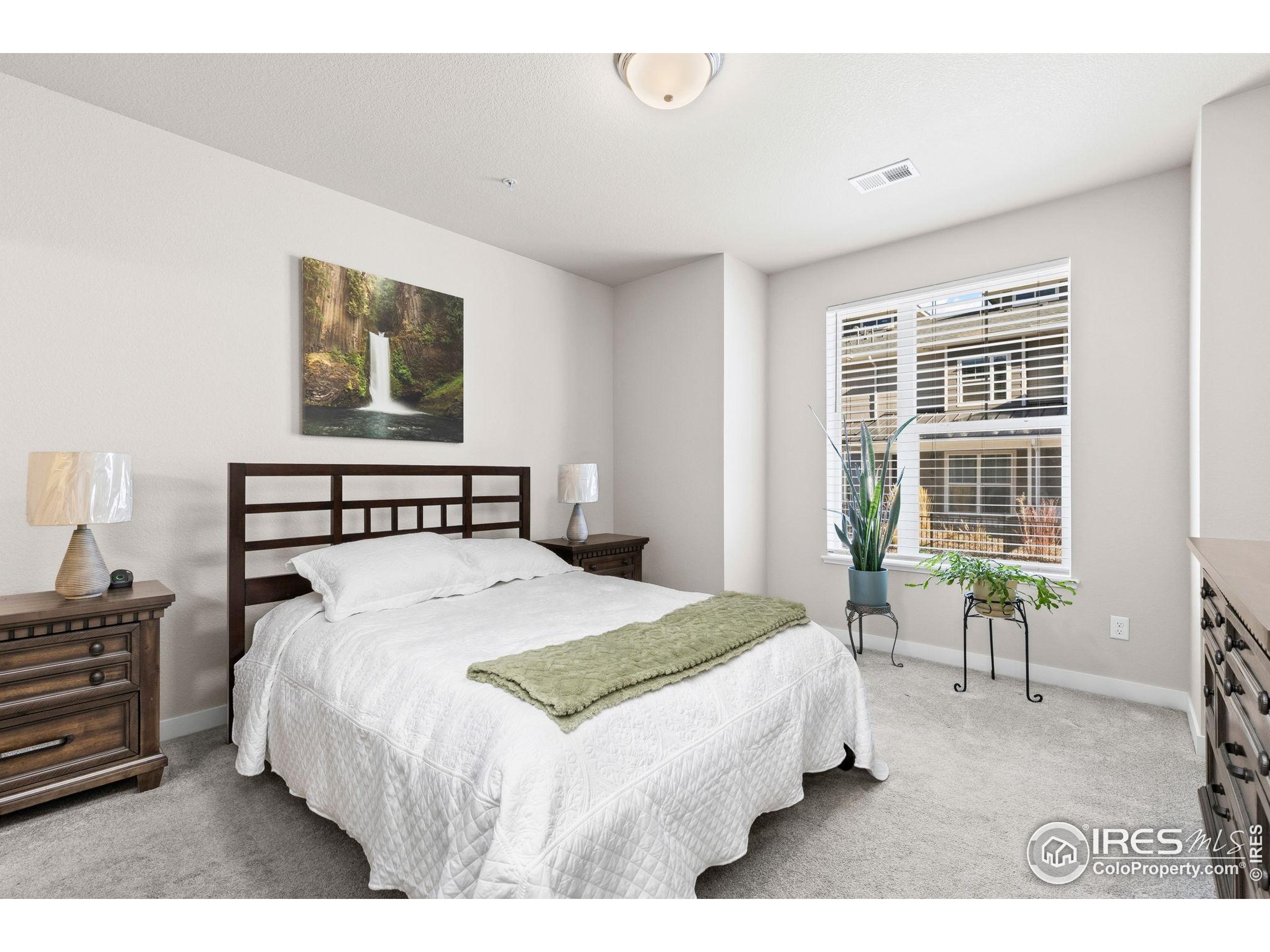 330 High Point Drive, Unit B103 Longmont, CO 80504 - Photo 12 of 18 a bedroom with a bed and chair