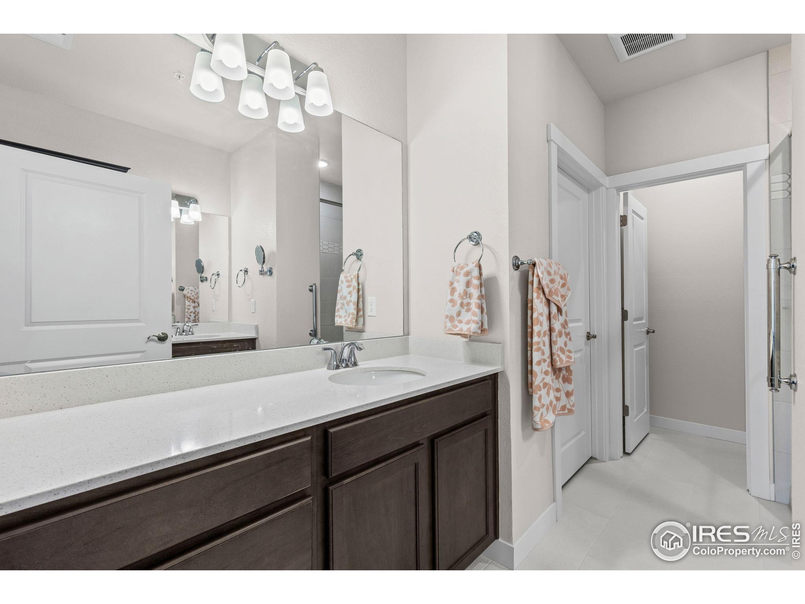 330 High Point Drive, Unit B103 Longmont, CO 80504 - Photo 15 of 18 a bathroom with a sink a shower and a mirror