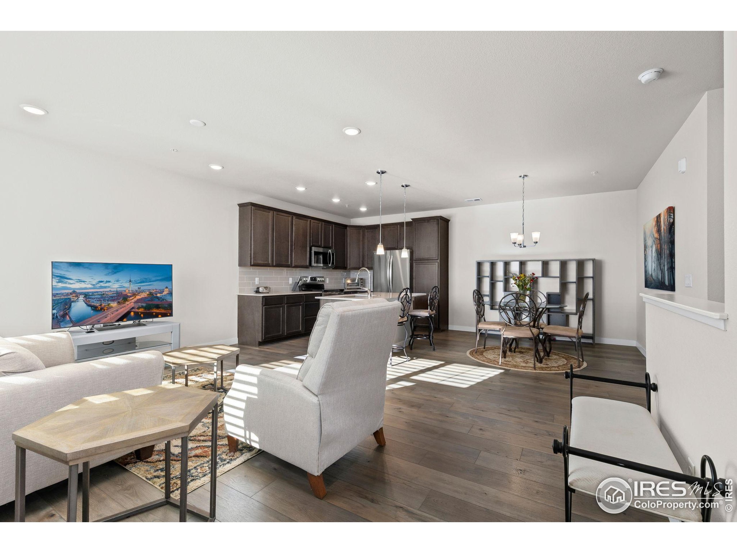 330 High Point Drive, Unit B103 Longmont, CO 80504 - Photo 4 of 18 a living room with furniture and a dining table with kitchen view
