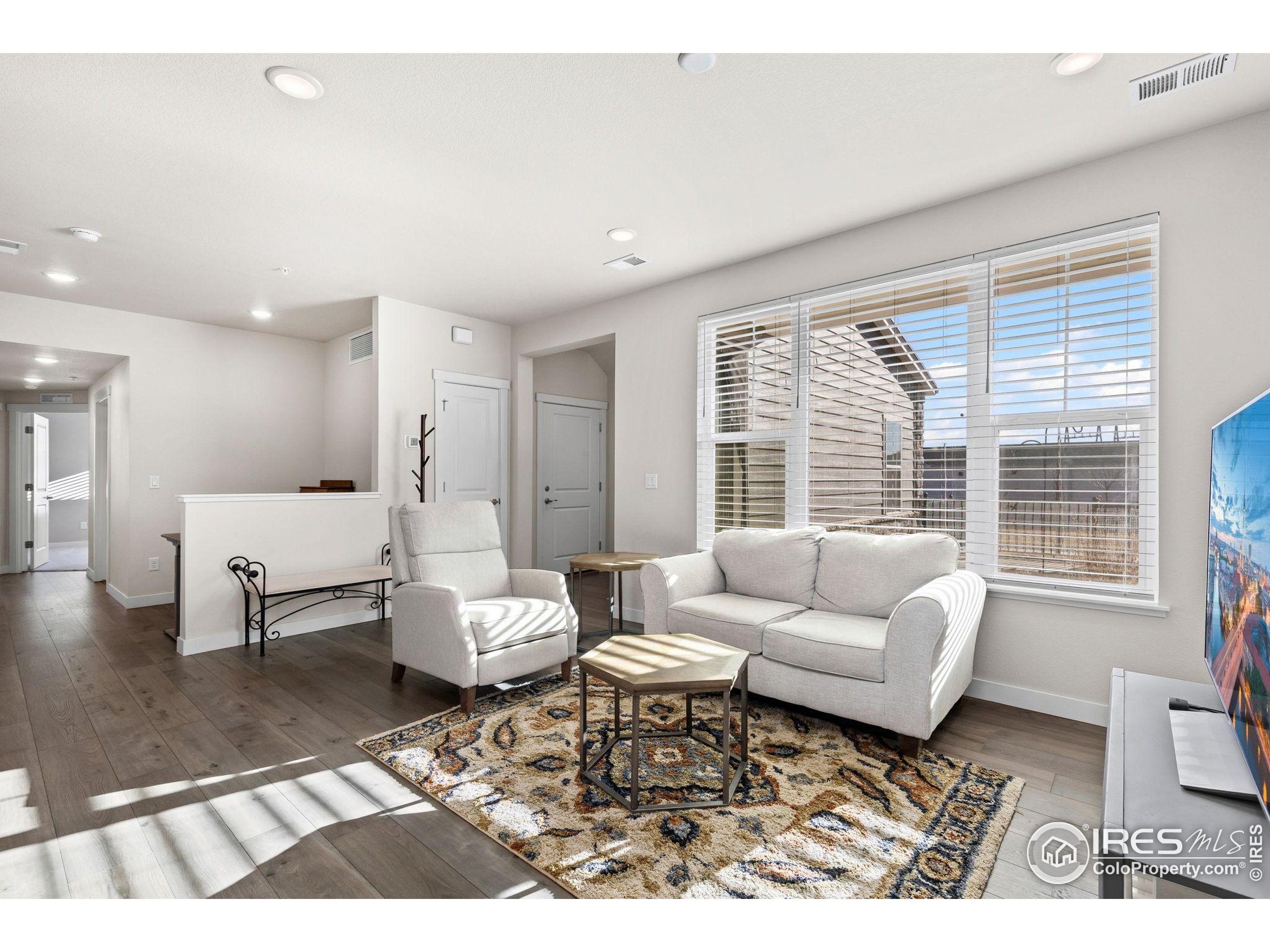 330 High Point Drive, Unit B103 Longmont, CO 80504 - Photo 5 of 18 a living room with furniture and a large window