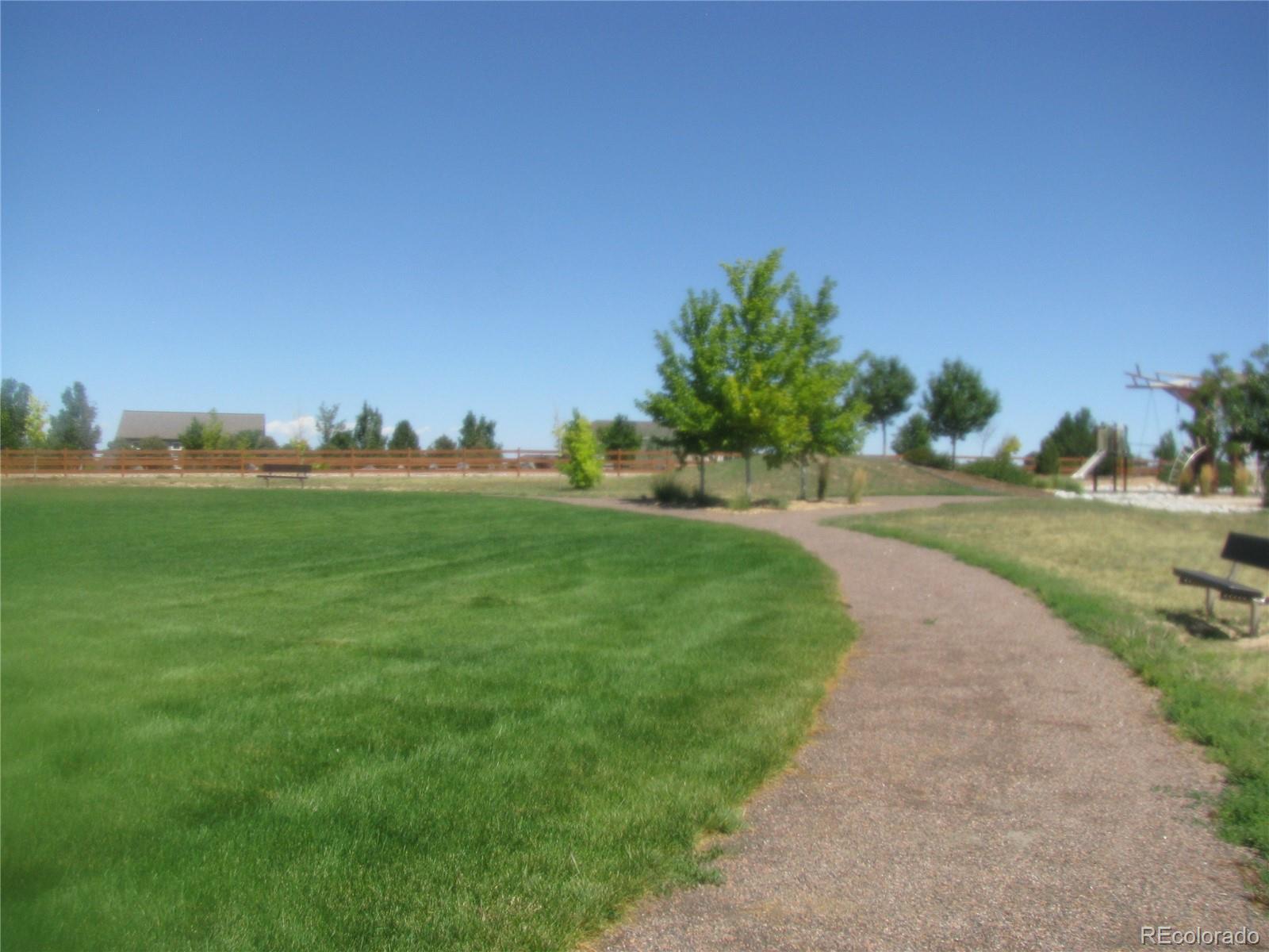993 Pinehurst Court Bennett, CO 80102 - Photo 7 of 9 a view of a grassy field with trees