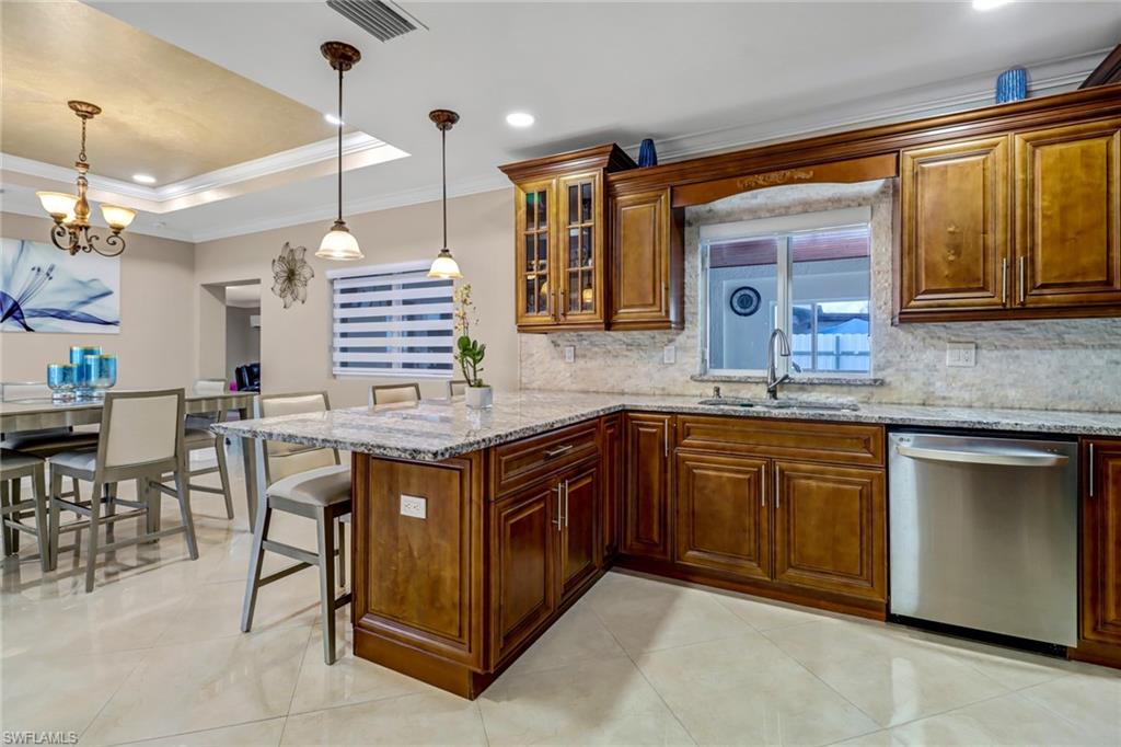 2001 43rd Terrace Southwest Naples, FL 34116 - Photo 12 of 27 a kitchen with a sink stove and cabinets