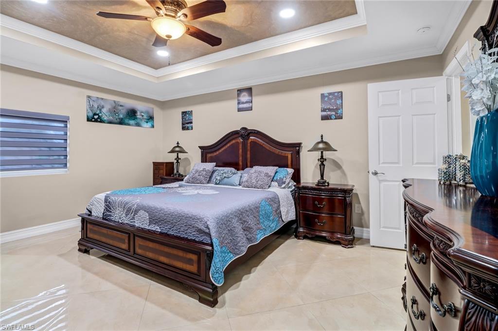 2001 43rd Terrace Southwest Naples, FL 34116 - Photo 14 of 27 a bedroom with a bed and a chandelier