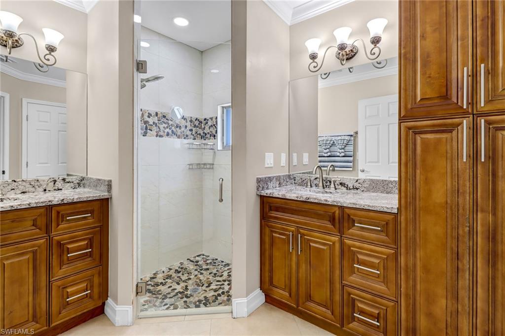 2001 43rd Terrace Southwest Naples, FL 34116 - Photo 15 of 27 a bathroom with a granite countertop sink a mirror and a shower