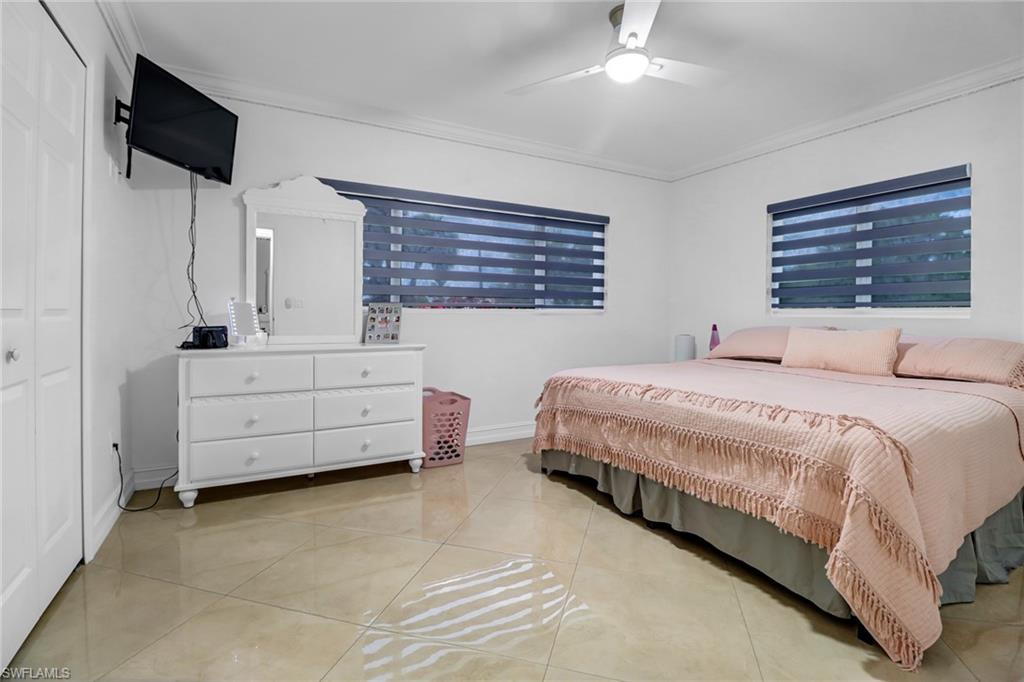 2001 43rd Terrace Southwest Naples, FL 34116 - Photo 20 of 27 a spacious bedroom with a bed and a tv