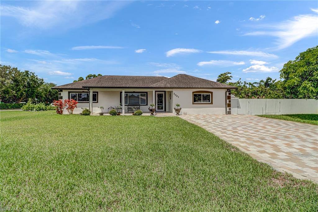 2001 43rd Terrace Southwest Naples, FL 34116 - Photo 2 of 27 a front view of a house with a yard
