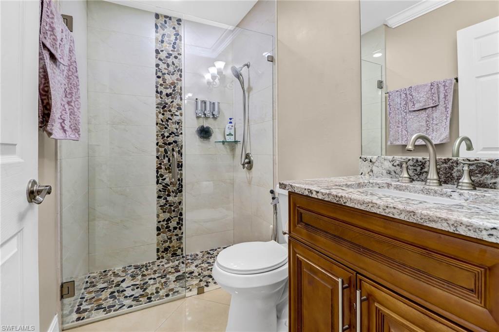 2001 43rd Terrace Southwest Naples, FL 34116 - Photo 21 of 27 a bathroom with a granite countertop sink toilet and shower