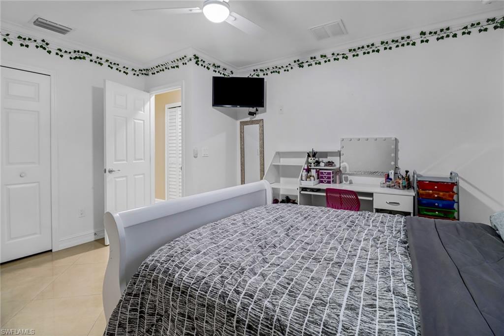 2001 43rd Terrace Southwest Naples, FL 34116 - Photo 22 of 27 a bedroom with a bed and a television