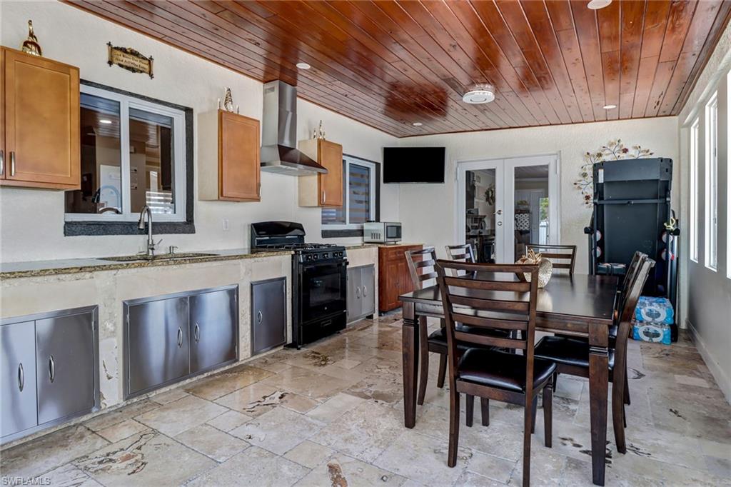 2001 43rd Terrace Southwest Naples, FL 34116 - Photo 24 of 27 a kitchen with stainless steel appliances granite countertop table chairs sink and cabinets