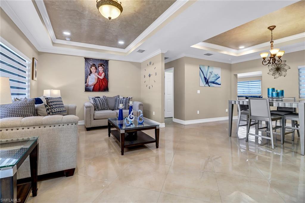 2001 43rd Terrace Southwest Naples, FL 34116 - Photo 5 of 27 a living room with furniture and a chandelier
