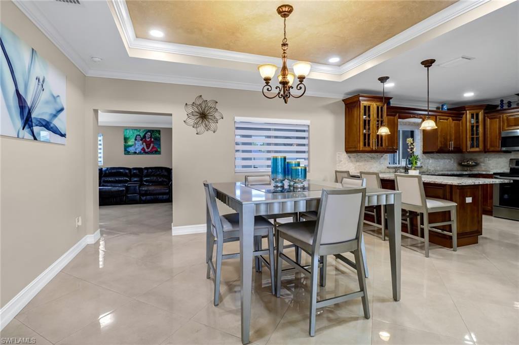 2001 43rd Terrace Southwest Naples, FL 34116 - Photo 8 of 27 a view of a dining room with furniture a chandelier and kitchen view